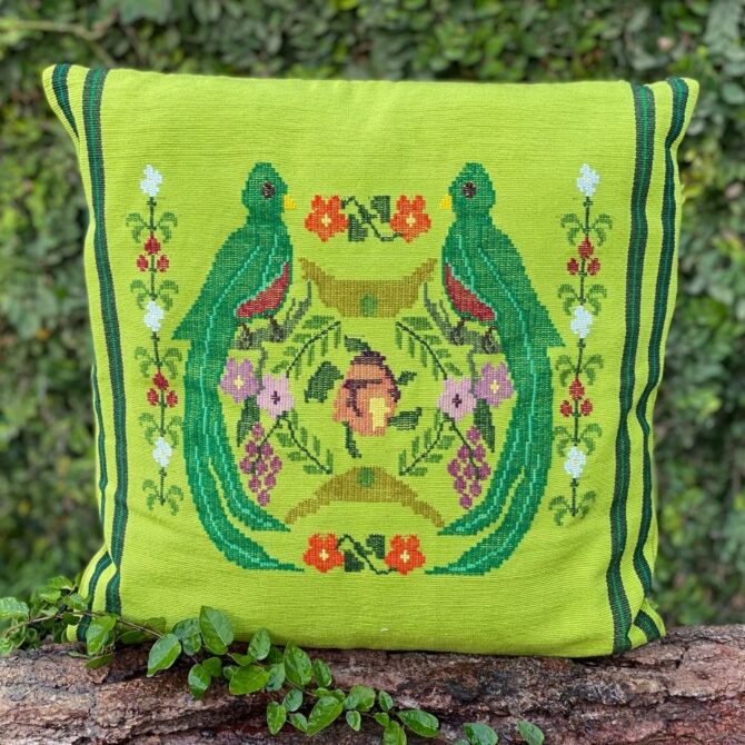 A bright green pillow case with 2 stripes down each side and 2 Quetzales (the Guatemalan national bird) and other adornments like flowers